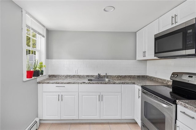 kitchen featuring appliances with stainless steel finishes, white cabinetry, a sink, and tasteful backsplash