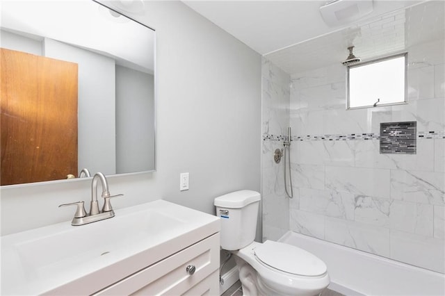 bathroom featuring tiled shower, vanity, and toilet