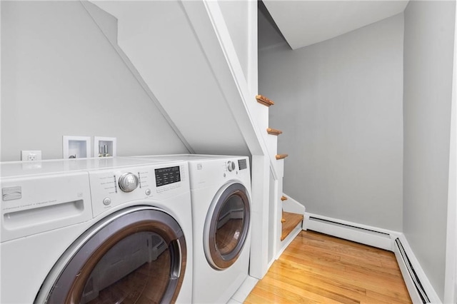 laundry room with baseboard heating, laundry area, washing machine and clothes dryer, and wood finished floors