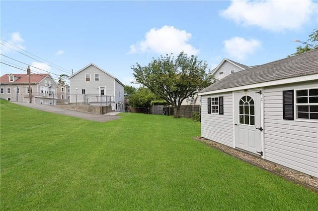 view of yard featuring an outbuilding and fence