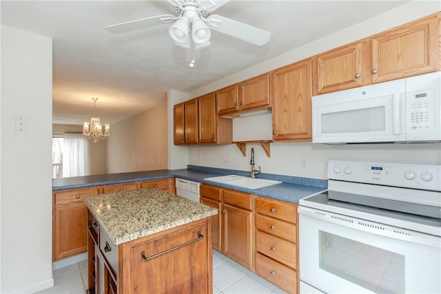 kitchen featuring light tile patterned floors, a kitchen island, a sink, white appliances, and ceiling fan with notable chandelier