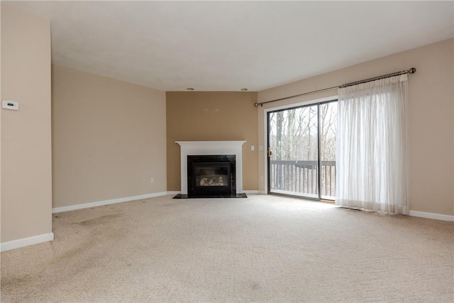 unfurnished living room with a fireplace with flush hearth, baseboards, and carpet flooring