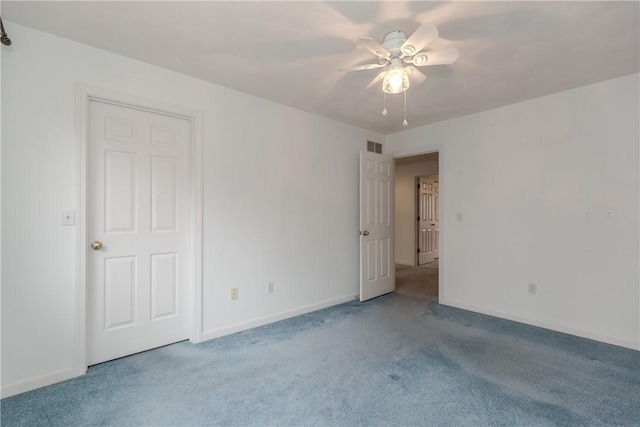 carpeted spare room with baseboards, visible vents, and a ceiling fan