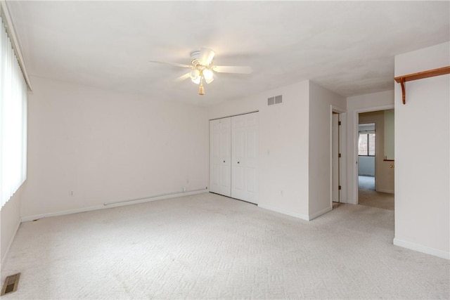 unfurnished bedroom with light carpet, baseboards, visible vents, and a closet