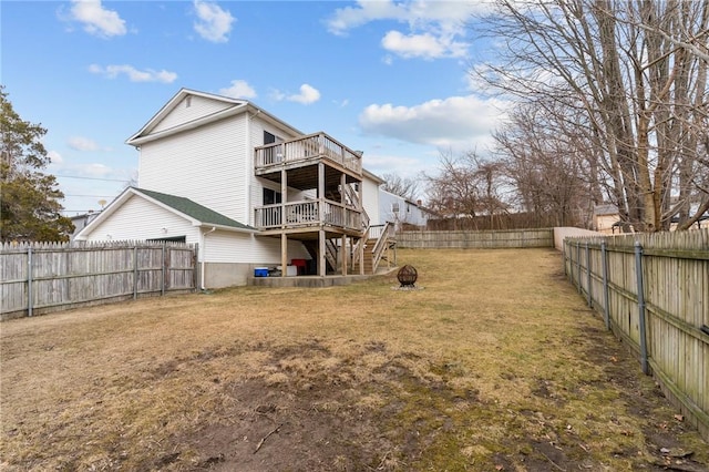 back of house with a yard, stairway, an outdoor fire pit, a fenced backyard, and a wooden deck