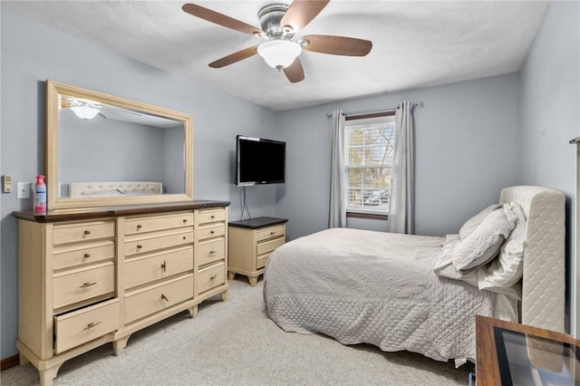 bedroom with light carpet and a ceiling fan