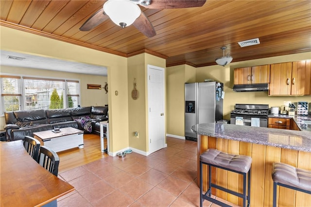 kitchen with visible vents, appliances with stainless steel finishes, ornamental molding, tile patterned flooring, and under cabinet range hood