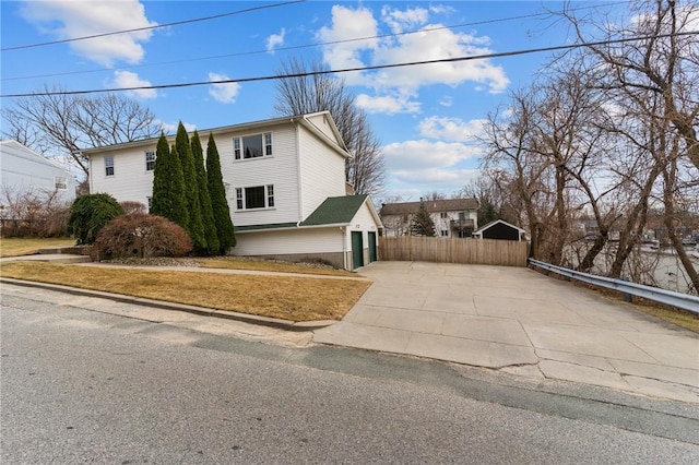 view of side of property featuring fence and driveway