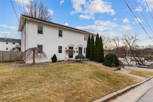 colonial-style house with fence and a front yard