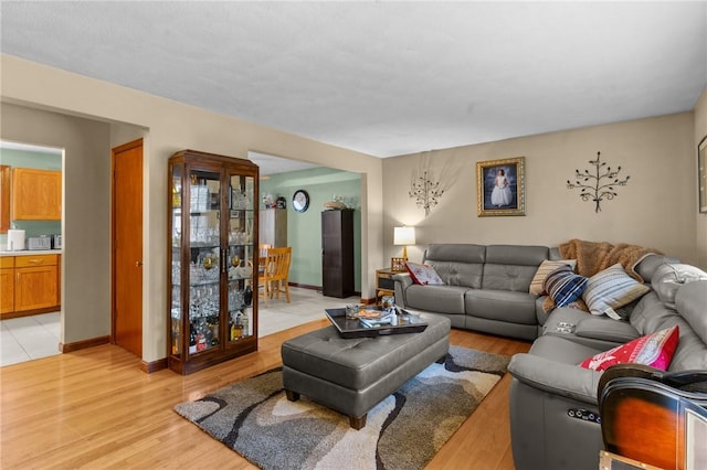 living area with light wood-type flooring and baseboards