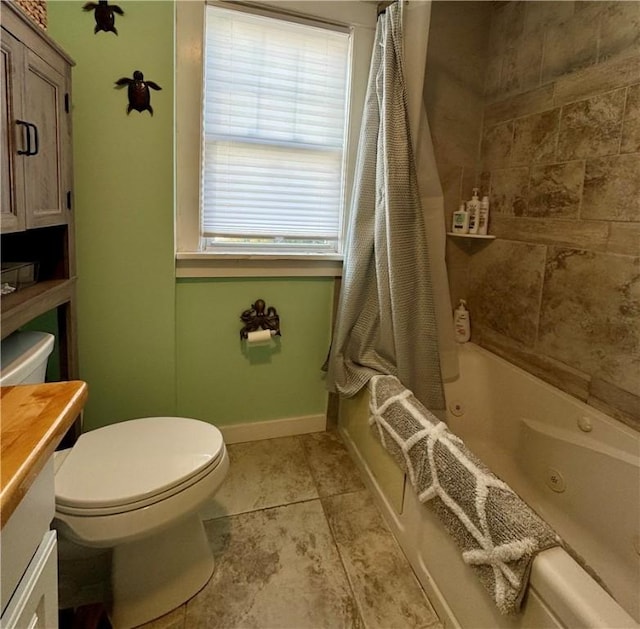 full bath with vanity, baseboards, a combined bath / shower with jetted tub, tile patterned flooring, and toilet