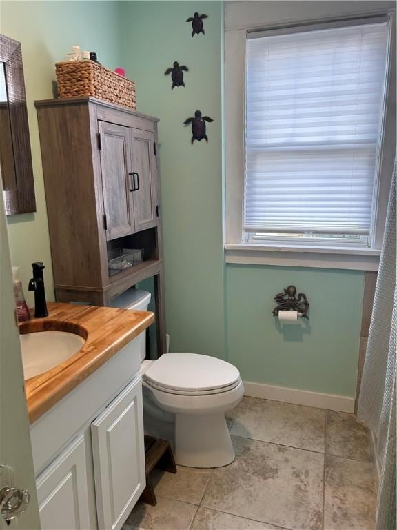 bathroom featuring tile patterned floors, toilet, vanity, and baseboards