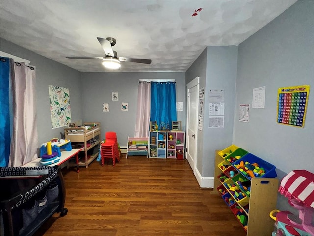 game room with a ceiling fan, baseboards, and wood finished floors