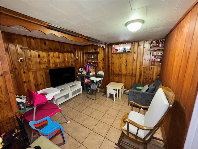 sitting room featuring wood walls and tile patterned floors