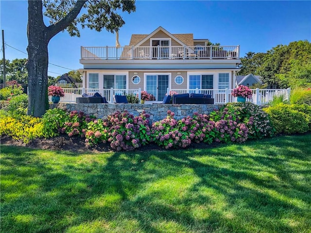 view of front of home featuring a front yard and a balcony