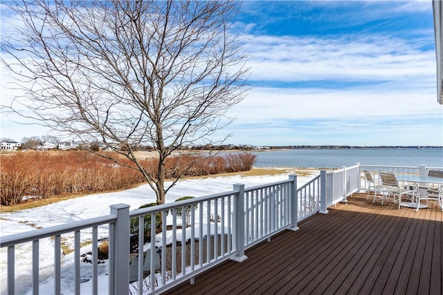 deck featuring outdoor dining space and a water view