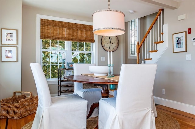 dining space featuring stairs, baseboards, and wood finished floors