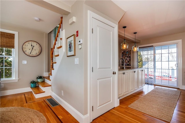 interior space with light wood-type flooring, plenty of natural light, and visible vents