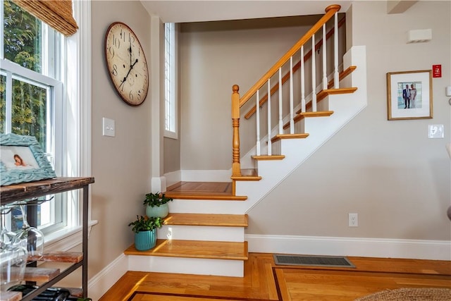 stairs featuring visible vents, baseboards, and wood finished floors