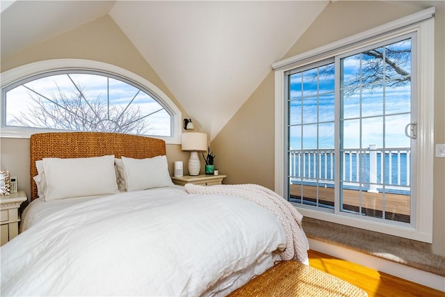 bedroom with lofted ceiling and wood finished floors