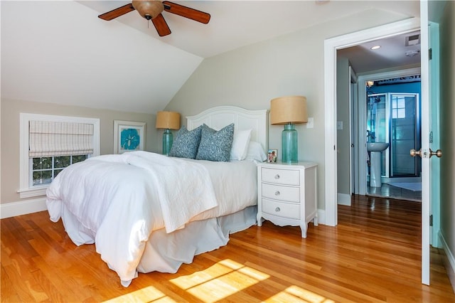 bedroom featuring vaulted ceiling, multiple windows, and light wood-style flooring