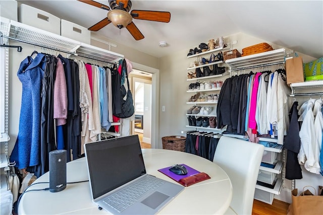 walk in closet featuring lofted ceiling, a ceiling fan, and wood finished floors