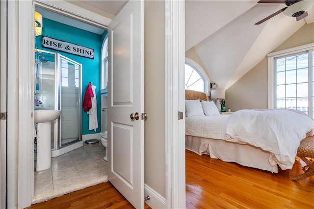 bedroom featuring a ceiling fan, vaulted ceiling, and wood finished floors