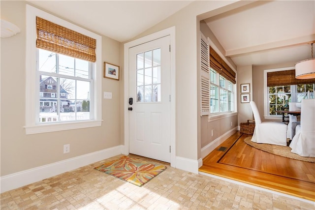 entryway with vaulted ceiling, visible vents, and baseboards