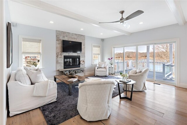 1040 Buttonwoods Ave, Warwick, RI 02886 - living area featuring beamed ceiling, a ceiling fan, plenty of natural light, a fireplace, and light wood-style flooring