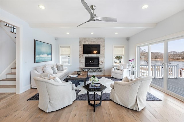 1040 Buttonwoods Ave, Warwick, RI 02886 - living room featuring stairs, beamed ceiling, baseboards, ceiling fan, and light wood-type flooring