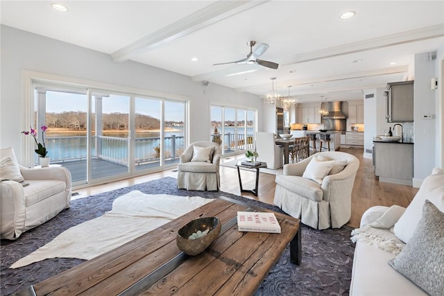 living area with light wood finished floors, beam ceiling, and recessed lighting