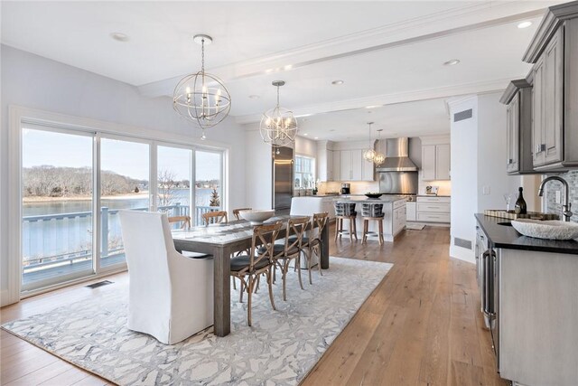 1040 Buttonwoods Ave, Warwick, RI 02886 - dining area featuring a chandelier, light wood finished floors, recessed lighting, a water view, and ornamental molding