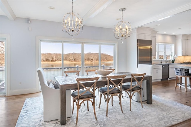 dining space featuring light wood-style floors, plenty of natural light, a chandelier, and beamed ceiling