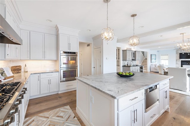 kitchen with double oven, extractor fan, stove, light wood-type flooring, and an inviting chandelier