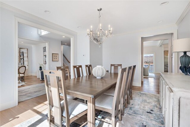 1040 Buttonwoods Ave, Warwick, RI 02886 - dining room featuring a chandelier, light wood-style floors, stairs, crown molding, and baseboards