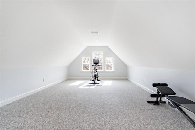 workout area featuring carpet, visible vents, vaulted ceiling, and baseboards