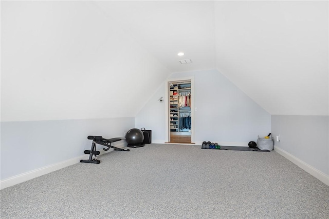 workout area featuring carpet floors, visible vents, baseboards, and vaulted ceiling