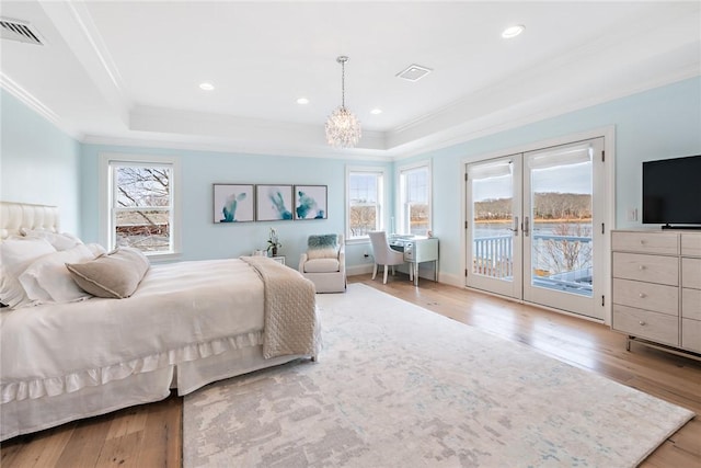 bedroom with access to exterior, wood-type flooring, visible vents, and a raised ceiling