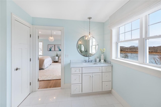 ensuite bathroom featuring ensuite bathroom, tile patterned flooring, vanity, and baseboards