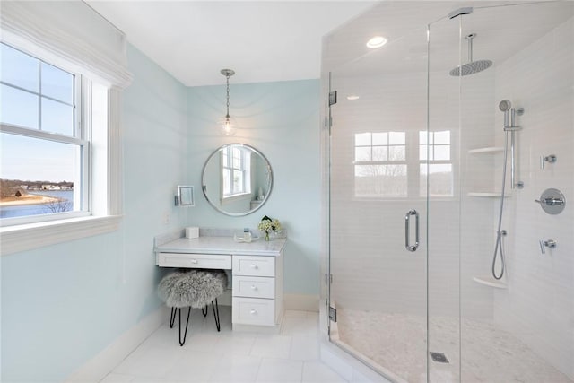 bathroom featuring baseboards, a shower stall, vanity, and tile patterned floors