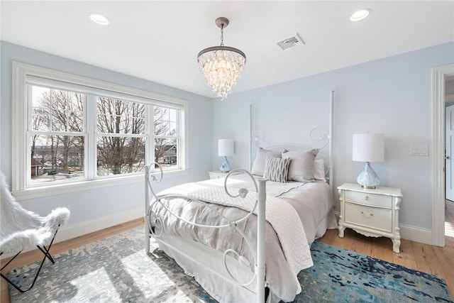 bedroom with light wood finished floors, recessed lighting, visible vents, a chandelier, and baseboards