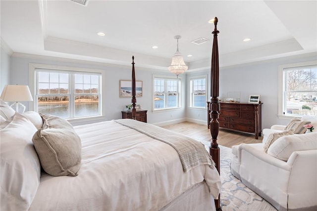 bedroom featuring light wood-style floors, baseboards, ornamental molding, and a raised ceiling