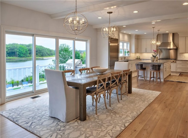 dining space featuring light wood-style flooring, beamed ceiling, visible vents, and a notable chandelier