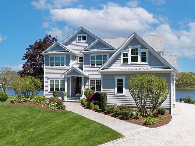 1040 Buttonwoods Ave, Warwick, RI 02886 - view of front facade featuring a front yard, a shingled roof, and a water view