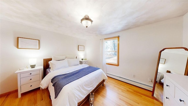 bedroom featuring light wood finished floors and a baseboard radiator