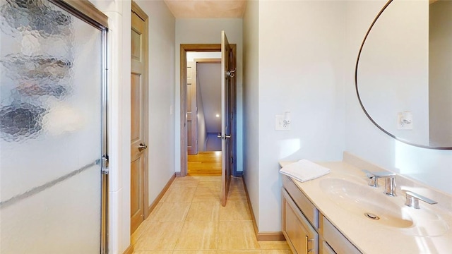 bathroom with tile patterned floors, a stall shower, vanity, and baseboards