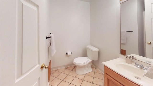 bathroom featuring tile patterned floors, baseboards, toilet, and vanity