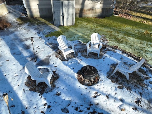 view of yard with a storage unit, a garage, an outdoor structure, and an outdoor fire pit