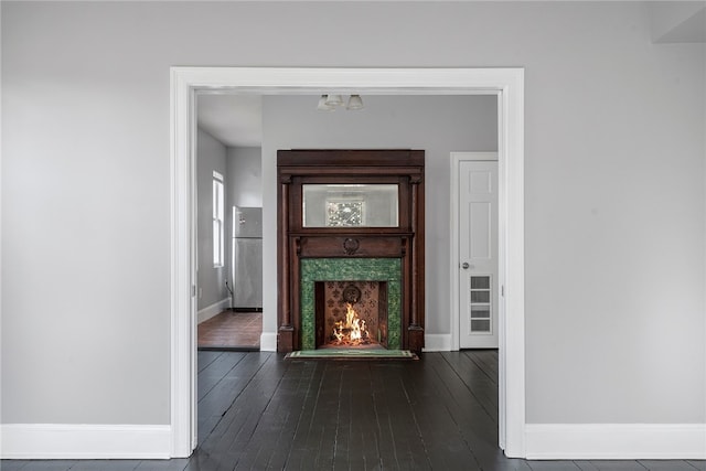 hallway with dark wood-style flooring and baseboards