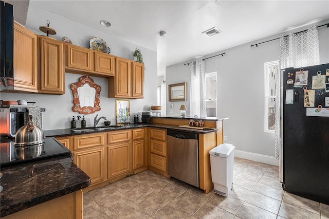 kitchen with light tile patterned flooring, stainless steel appliances, a peninsula, a sink, and visible vents